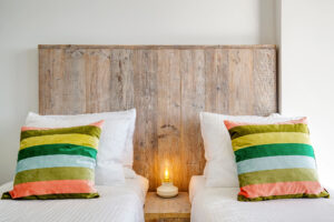 a bed with pillows and a lamp on the side