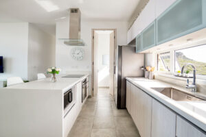 a kitchen with white cabinets and a white clock