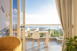 a room with a table and chairs and a view of the ocean